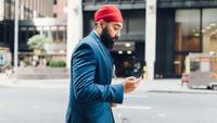 Businessman in city using smartphone, walking in the street