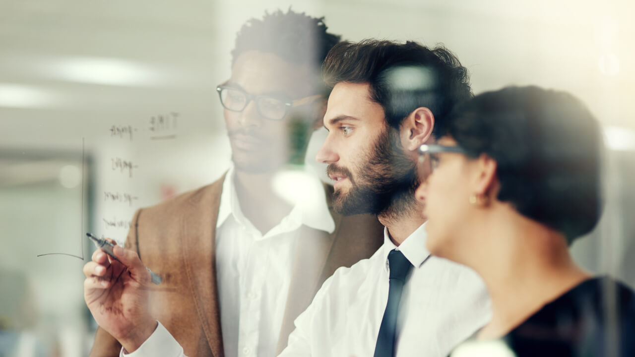Business people planning while writing on glass together