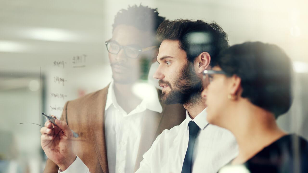 Business people planning while writing on glass together